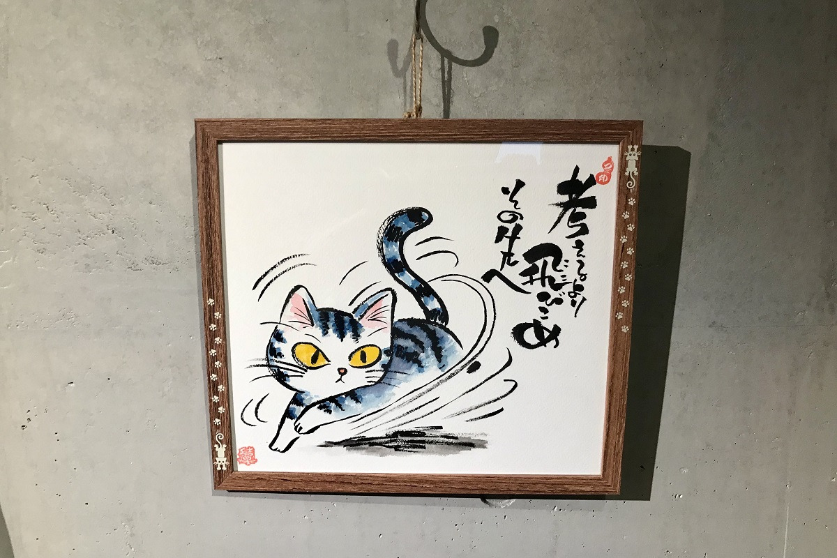 「考えるより飛びこめその先へ」と書かれた猫の絵
